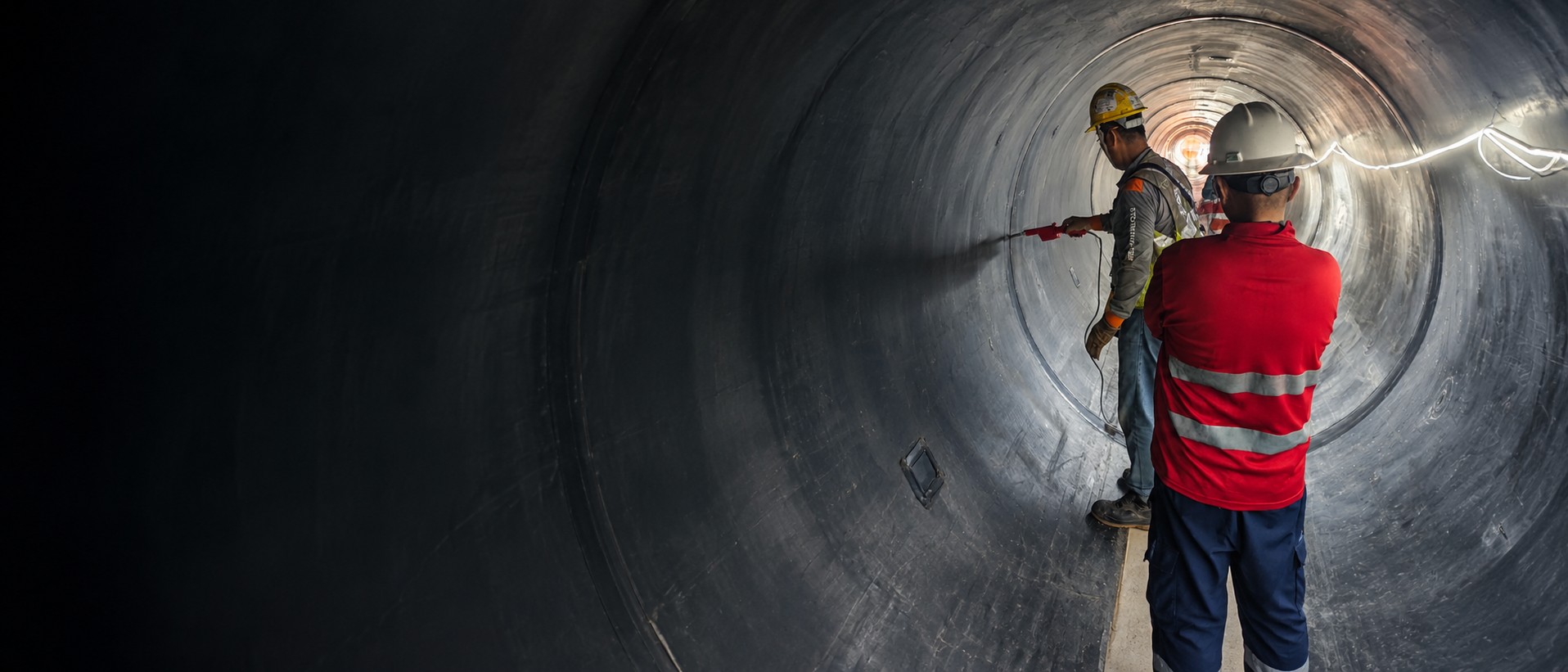 Technicians inspecting HDPE-lined tunnel