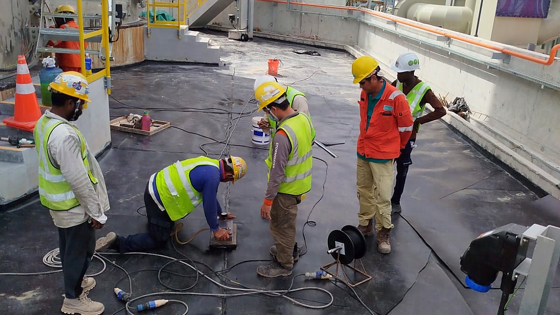 Stormwater installation team at work on a rooftop membrane project in Singapore