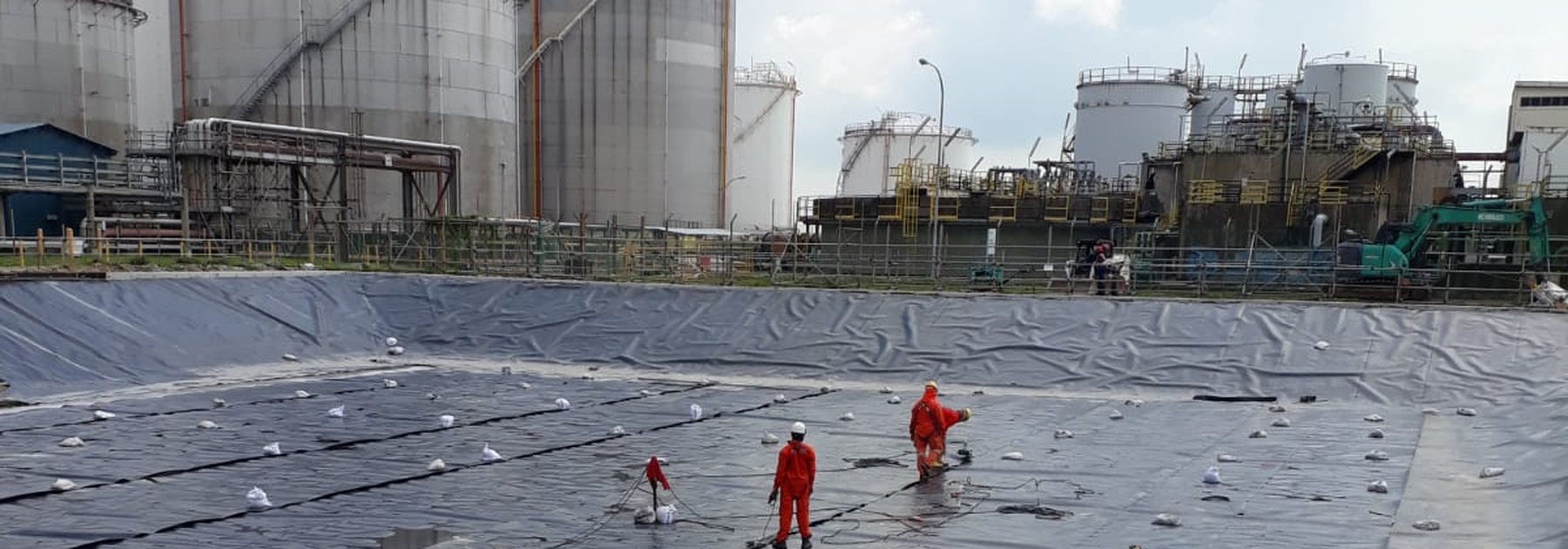 HDPE geomembrane liner panels being placed in a containment basin at a Jurong Island tank farm